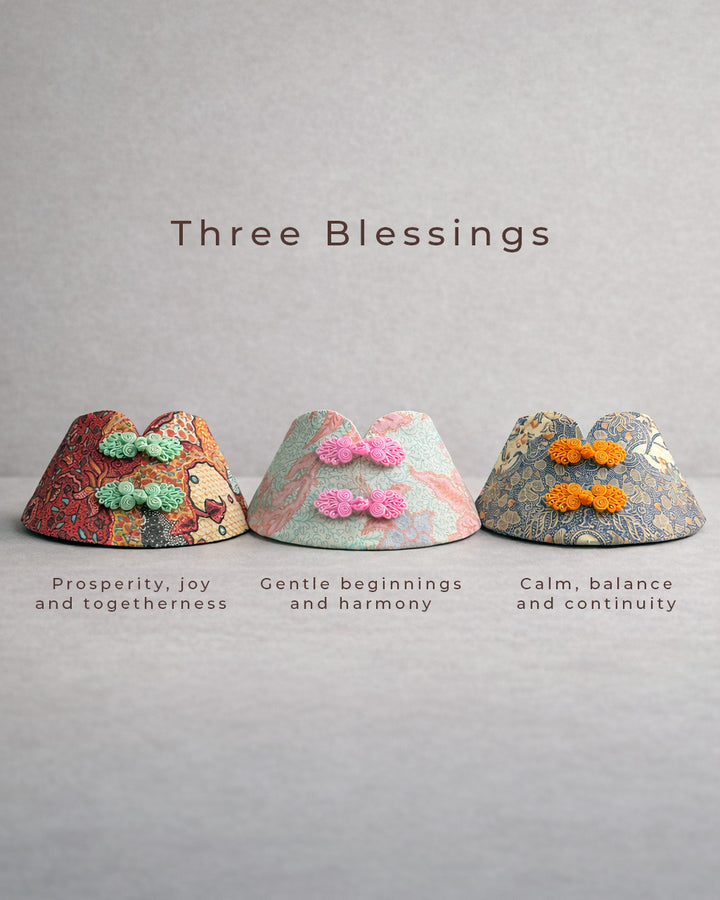Three decorative pet bibs with batik patterns on a gray background, labeled 'Three Blessings'.